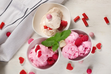 Bowls with delicious raspberry ice-cream on wooden table