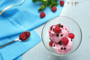 Glass dessert bowl with delicious raspberry ice-cream on table