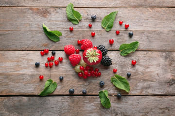 Delicious ripe berries on wooden background