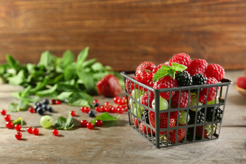 Basket with delicious berries on wooden table