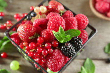 Basket with delicious berries on table, closeup