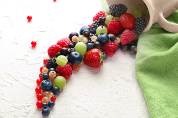 Composition with delicious ripe berries on light background