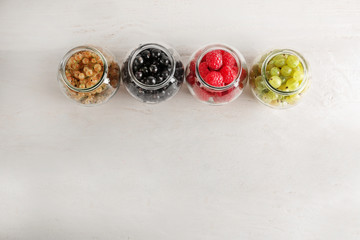 Obraz na płótnie Canvas Glass jars with delicious ripe berries on table