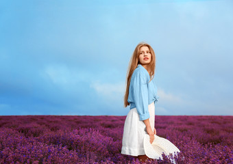 Fototapeta na wymiar Beautiful young woman in lavender field on summer day