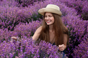 Beautiful young woman in lavender field on summer day