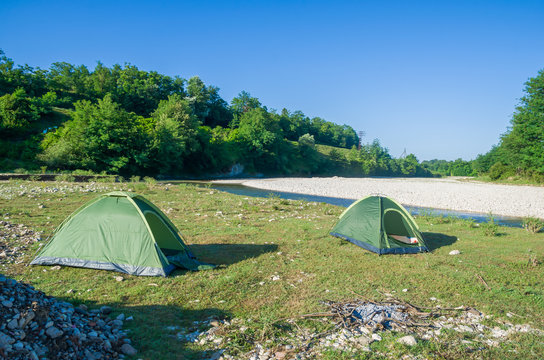 The camping tents near mountain river in the summer
