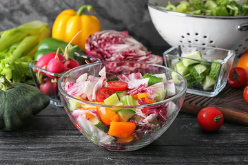 Bowl with tasty vegetable salad on wooden table