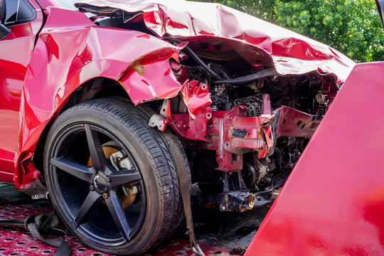 Front of red car get damaged by accident on the road