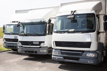 transport service company delivery and service van trucks front of factory warehouse distribution
