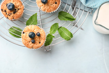 Cooling rack with tasty blueberry muffins on table