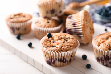 White board with tasty blueberry muffins on table