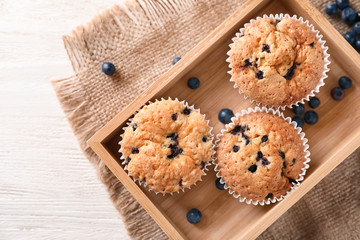 Fototapeta na wymiar Wooden box with blueberry muffins on table