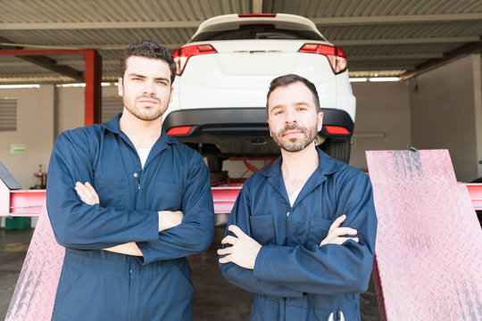 Proud Colleagues With Arms Crossed In Automotive Shop
