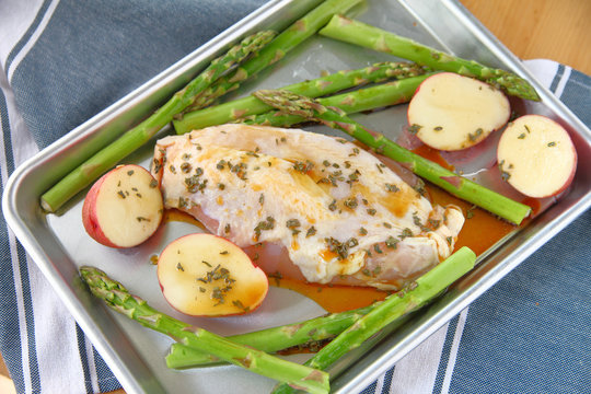 Chicken Breast On Half Sheet Pan With Asparagus And Small Red Potatoes