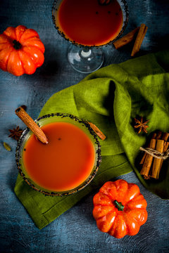 Autumn spicy pumpkin martini with cinnamon, anise stars and black sesame decoration, dark blue background copy space