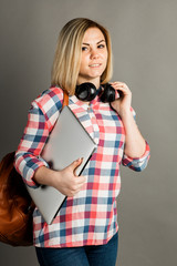 Studio portrait of a beautiful student girl or businesswoman holding laptop computer.