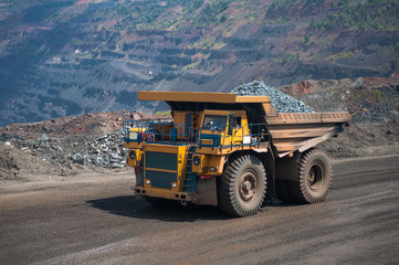 The work of a heavy quarry dump truck in the iron ore quarry.	