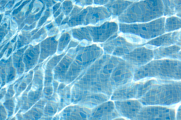 Background of swimming pool water showing blue tiles beneath