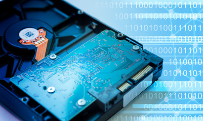 Closeup detail of Hard disk circuit with blue Binary code background