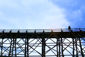 The silhouette man on wooden bridge, Bridge across the river and Mon wood bridge at sangklaburi, kanchanaburi