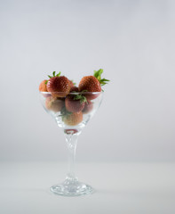Strawberry, fresh and red berries in glass at white background