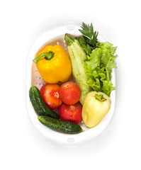 Fresh vegetables in a colander bowl on a white background