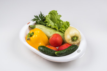 Fresh vegetables in a colander bowl on a white background