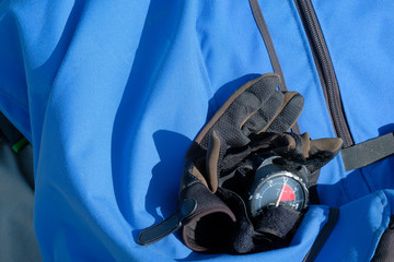 gloves for the parachute sport with an altimeter lie on the background of a blue bag