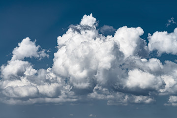 Naklejka na ściany i meble massive dramatic cumulus cloud in the blue sky