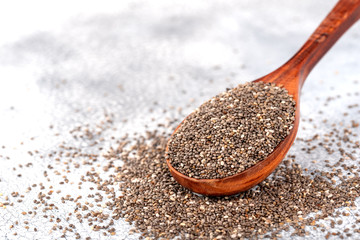 Healthy Chia seeds in a wooden spoon on the table close-up.