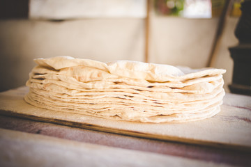 Close up image of a cook rolling out dough for gourmet wood fired pizza bases