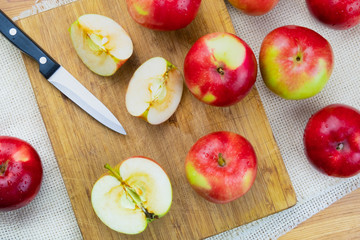 Top view of ripe juicy apples on rustic wooden table. Home grown organic apples and knife, shot from above