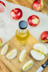 Top view cidre bottle on and ripe apples rustic wooden table. Glass and bottle of home made cider and locally grown organic apples, shot from above