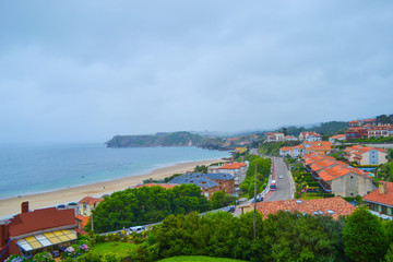 Fototapeta na wymiar View of beach and town of Comillas from Guell and Martos park. Nice sightseeing. Comillas, Cantabria, Spain