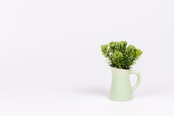 Artificial flowers in green vase on white background