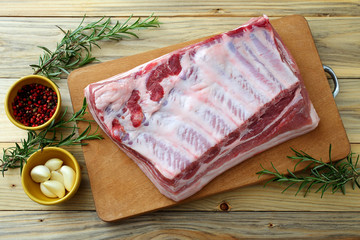 carne di porco cruda costolette e petto su tagliere di legno