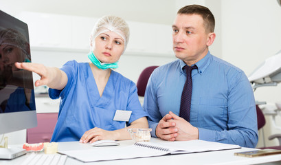 Obraz premium Female dentist discussing treatment with patient