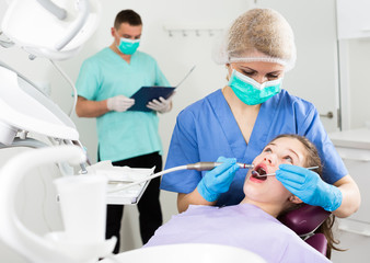 Fototapeta premium Female dentist with girl patient during oral checkup