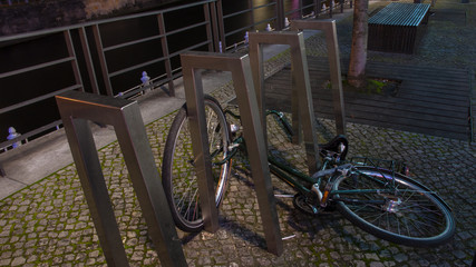 Fototapeta na wymiar Bicycle resting along a city canal at night, in Berlin, Germany.