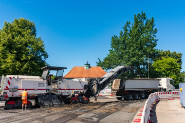 Strassenfräse trägt den alten Belag der Strasse ab