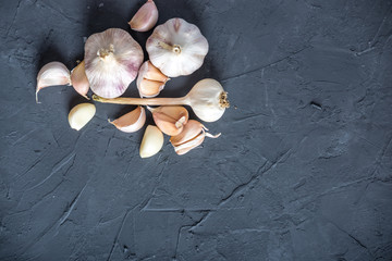 Group of garlic cloves scattered on a dark background. Important ingredient in different cuisines of the world © Artem