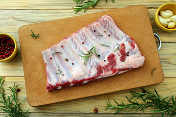 costolette di maiale crude su tagliere di legno