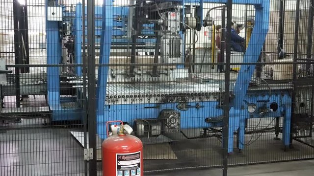 Feeding cardboard boxes of red wine to the palletizer machine