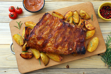 costolette di maiale BBq o alla griglia con patate arrosto su sfondo tavolo di cucina