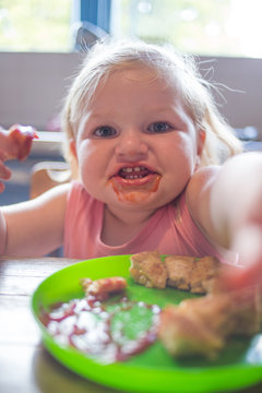 Close up image of a toddler girl enjoying a toasted cheese sandwich