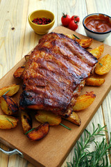 costolette di maiale BBq o alla griglia con patate arrosto su sfondo tavolo di cucina