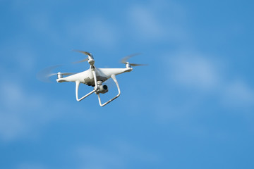 Naklejka na ściany i meble Drone quadcopter with digital camera, Drone hovering in blue sky