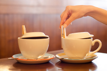 Two cups of tea female hand on the table cafe