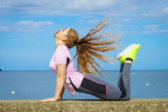 Woman doing yoga next to sea