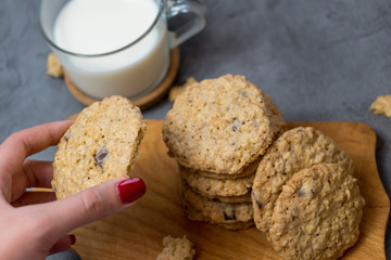 Oatmeal cookies and milk on a wooden board and gray background